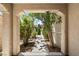 Landscaped front yard view framed by an arched entryway, showcasing greenery and a peaceful ambiance at 9074 Iron Cactus Ave, Las Vegas, NV 89148