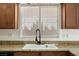 Close-up of the kitchen sink with granite countertops and traditional faucet at 9074 Iron Cactus Ave, Las Vegas, NV 89148