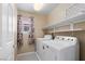 Bright laundry room with washer, dryer, shelves, and window at 9074 Iron Cactus Ave, Las Vegas, NV 89148