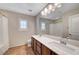 Bathroom featuring double sinks, a large mirror, modern lighting, and shuttered windows at 9542 Ridgeglen Ct, Las Vegas, NV 89148