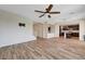 Open-concept living room with lots of space, neutral paint, and wood-look tile flooring at 9542 Ridgeglen Ct, Las Vegas, NV 89148