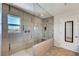 Modern walk-in shower boasts sleek tile work, glass enclosure, rainfall shower head and bench at 9542 Ridgeglen Ct, Las Vegas, NV 89148