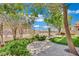 Landscaped backyard featuring synthetic grass putting green, stone landscaping, and mature trees at 96 Saint Johns Wood Ave, Henderson, NV 89002