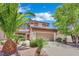 Front exterior view of a two-story home with a two-car garage and desert landscaping at 96 Saint Johns Wood Ave, Henderson, NV 89002