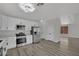 Modern kitchen with stainless steel appliances, white cabinetry and grey hardwood style floors at 96 Saint Johns Wood Ave, Henderson, NV 89002