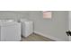 Bright laundry room featuring a washer, dryer, window and wood plank flooring at 96 Saint Johns Wood Ave, Henderson, NV 89002