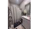 Cozy bathroom featuring a shower with curtain, neutral-colored walls, decorative mirror and vanity with a white cabinet at 10163 Kings Amethyst St, Las Vegas, NV 89141