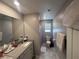 Clean bathroom with a vanity, a large mirror, a toilet, and a window that provides natural light at 10163 Kings Amethyst St, Las Vegas, NV 89141