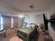 Bright bedroom with a bed, lamps on the night stands, a ceiling fan, window with curtains, and neutral-colored walls at 10163 Kings Amethyst St, Las Vegas, NV 89141
