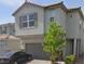 Charming two-story home with a two-car garage, stone accents, paved driveway and lush landscaping at 10163 Kings Amethyst St, Las Vegas, NV 89141
