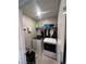 Well-lit laundry room with new washer and dryer, plus overhead storage shelving for added convenience at 10163 Kings Amethyst St, Las Vegas, NV 89141