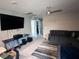 Comfortable living room with a large sectional sofa, big screen TV, ceiling fan, and neutral-colored walls at 10163 Kings Amethyst St, Las Vegas, NV 89141