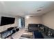 Comfortable living room with a large sectional sofa, big screen TV, ceiling fan, and neutral-colored walls at 10163 Kings Amethyst St, Las Vegas, NV 89141