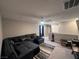 Spacious room with a large sectional sofa, big screen TV, neutral-colored walls, ceiling fan, and gray carpeting at 10163 Kings Amethyst St, Las Vegas, NV 89141