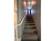 Carpeted staircase leading to the upper level of the home, with a white handrail and natural light at 10163 Kings Amethyst St, Las Vegas, NV 89141