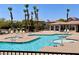 Community pool surrounded by lounge chairs and palm trees at 1169 Via Piazza, Henderson, NV 89052