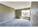 Upstairs bedroom featuring gray carpeting, a window, and a mirrored wall to make the room feel bigger at 1480 Hialeah Dr # B, Las Vegas, NV 89119