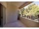 Outdoor balcony with stucco walls, offering a private space with views of mature trees at 1705 King James St # 203, Las Vegas, NV 89144