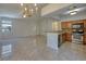 Bright living room with tile flooring, chandelier lighting, and an adjacent kitchen with modern appliances at 1705 King James St # 203, Las Vegas, NV 89144
