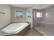 Bathroom showcasing a jacuzzi tub, frameless glass shower, and bright natural light at 1919 Belcastro St, Las Vegas, NV 89117