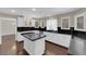 Kitchen features an island cooktop, sleek black counters and white cabinets at 1919 Belcastro St, Las Vegas, NV 89117