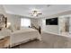 Comfortable main bedroom featuring plush carpeting, ceiling fan, and adjacent bathroom at 1919 Belcastro St, Las Vegas, NV 89117