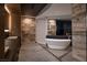Contemporary bathroom with soaking tub and vanity featuring stone accents and modern fixtures at 21 Rockstream Dr, Henderson, NV 89012