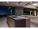 Kitchen island with black countertop and sink offering views of the city lights at night at 21 Rockstream Dr, Henderson, NV 89012