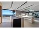 Modern kitchen island features an eat-in bar, sink, black countertops, and city views at 21 Rockstream Dr, Henderson, NV 89012