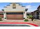 Charming home with a brown garage door and a beautifully landscaped yard at 2175 Limestone Cove Ct, Laughlin, NV 89029