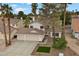 Exterior elevation view of home featuring a 2-car garage, desert landscaping, and mature palm trees at 2344 Valleywood St, Henderson, NV 89014