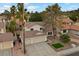 Exterior elevation view of home featuring a 2-car garage, desert landscaping, and mature palm trees at 2344 Valleywood St, Henderson, NV 89014