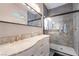 Modern bathroom featuring a dual-sink vanity with marble countertop and a walk-in shower with gray tiling at 2354 Buffalo Run Ave, Las Vegas, NV 89123
