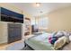 Comfortable bedroom with a large TV, two dressers, and a sunlit window at 2354 Buffalo Run Ave, Las Vegas, NV 89123