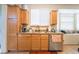Functional kitchen space with light wood cabinets, a granite countertop, and a stainless steel dishwasher at 2354 Buffalo Run Ave, Las Vegas, NV 89123