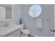 Bright bathroom with modern vanity, round accent window, and coordinated fixtures at 2860 Misty Ct, Henderson, NV 89074
