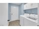 Bright laundry room featuring a washer, dryer, white cabinets and door to outside at 2860 Misty Ct, Henderson, NV 89074