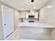 Modern kitchen featuring white cabinetry, updated appliances, and a breakfast bar with marble flooring at 3215 Dillon Ave, North Las Vegas, NV 89030