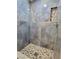 The shower features a river rock floor, stylish tile walls, and convenient built-in shelving at 3215 Dillon Ave, North Las Vegas, NV 89030
