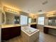Bright primary bathroom featuring a soaking tub, dual vanities and modern fixtures at 3221 Villa Pisani Ct, North Las Vegas, NV 89031