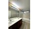 Bright bathroom featuring a double sink vanity and a shower-tub combination with marble-look tile at 3221 Villa Pisani Ct, North Las Vegas, NV 89031