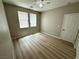 Bedroom with dual windows, laminate flooring, light-colored walls, and standard door at 3221 Villa Pisani Ct, North Las Vegas, NV 89031
