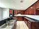 Gourmet kitchen featuring granite counters, a stainless steel sink, and custom dark wood cabinets at 3221 Villa Pisani Ct, North Las Vegas, NV 89031