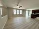 Open-concept living room with laminate flooring, natural light, and view of the kitchen island at 3221 Villa Pisani Ct, North Las Vegas, NV 89031