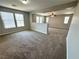 Spacious living room featuring neutral walls, plush carpeting, and large windows for ample natural light at 3221 Villa Pisani Ct, North Las Vegas, NV 89031