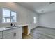 Functional kitchenette with white cabinets, sink, and gray-tone wood flooring at 365 N 16Th St, Las Vegas, NV 89101
