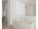 Bright bathroom featuring a soaking tub, an oversized mirror, and white tiled walls at 3726 Las Vegas Blvd # 704, Las Vegas, NV 89158