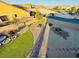 Private backyard featuring artificial grass, desert landscaping, and brick-paved firepit area at 4076 Topaz Hills Dr, North Las Vegas, NV 89032