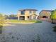 Spacious backyard with a covered patio, balcony, and low maintenance desert landscaping at 4076 Topaz Hills Dr, North Las Vegas, NV 89032