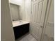 Bathroom with dark wood cabinets, large mirror, and tile flooring at 4076 Topaz Hills Dr, North Las Vegas, NV 89032